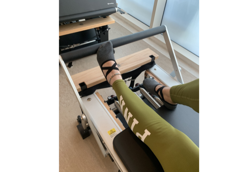 I am on the pilates reformer in olive green workout tights. 